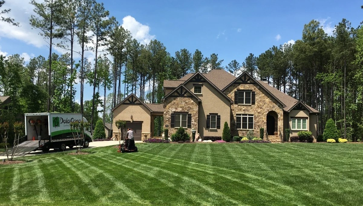 DalaCasa Landscape Management mowing a lawn with diamond pattern in Charlotte, NC.