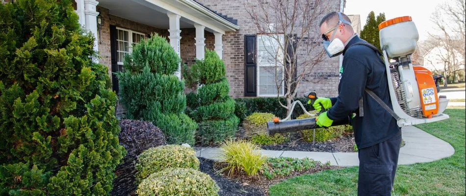 Crew treating trees and shrubs in Waxhaw, NC, with fertilizer.