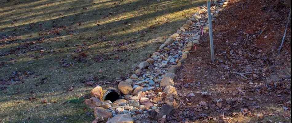 A dry creek bed in Charlotte, NC, leading to a drain.