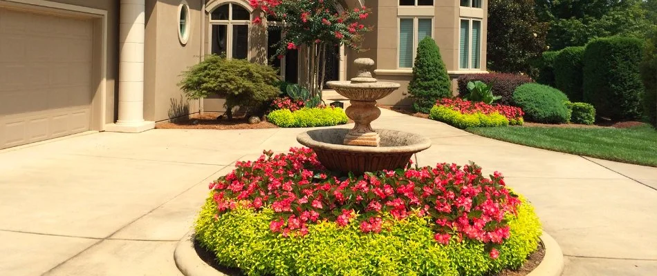 Flowers around a fountain on a driveway in Enochville, NC.