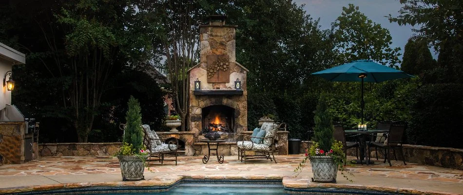 Outdoor fireplace and patio with pool in Kannapolis, NC.
