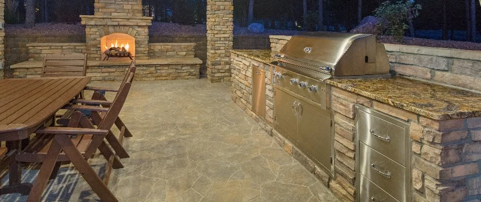 Outdoor kitchen, fireplace, and table in Charlotte, NC.