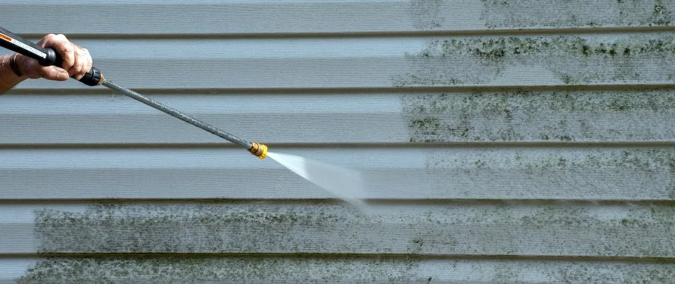 Pressure washing dirt off the side of a building in Charlotte, NC.